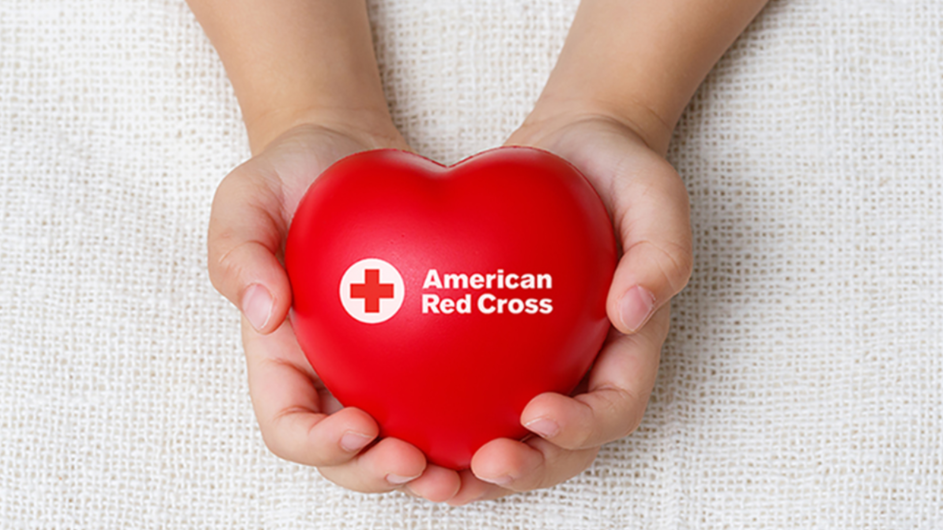Hand holding branded heart-shaped object