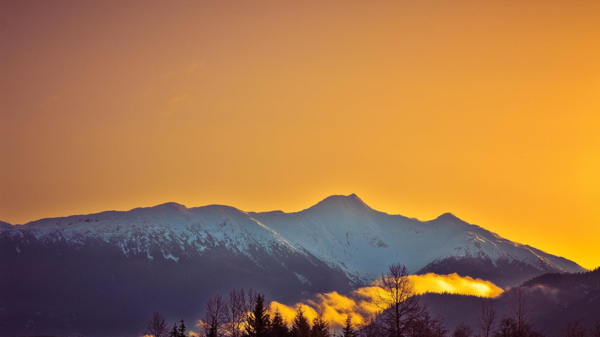 Orange sunrise over a snowy mountain