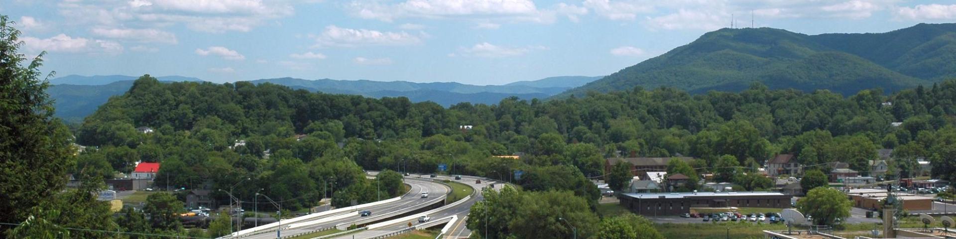 A train traveling down a road in a mountainous area