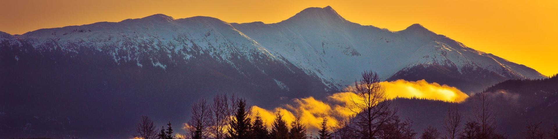 Orange sunrise over a snowy mountain