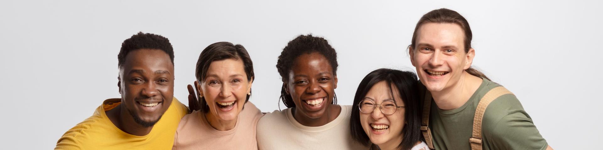 Group photo of five individuals with diverse backgrounds, showing joy.